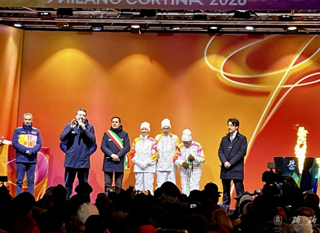 La Fiamma Olimpica torna a Cortina 70 anni dopo: Largo delle Poste gremito tra memoria del 1956 e attesa per Milano Cortina 2026
